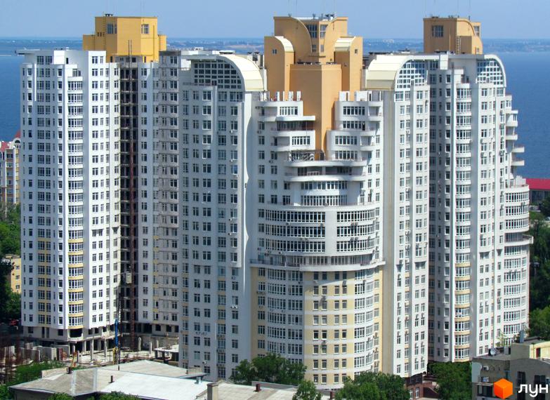 Житловий комплекс Французький бульвар, 22/30: висотні білі будинки з вигнутими фасадами та балконами, розташовані біля моря серед зелені.
