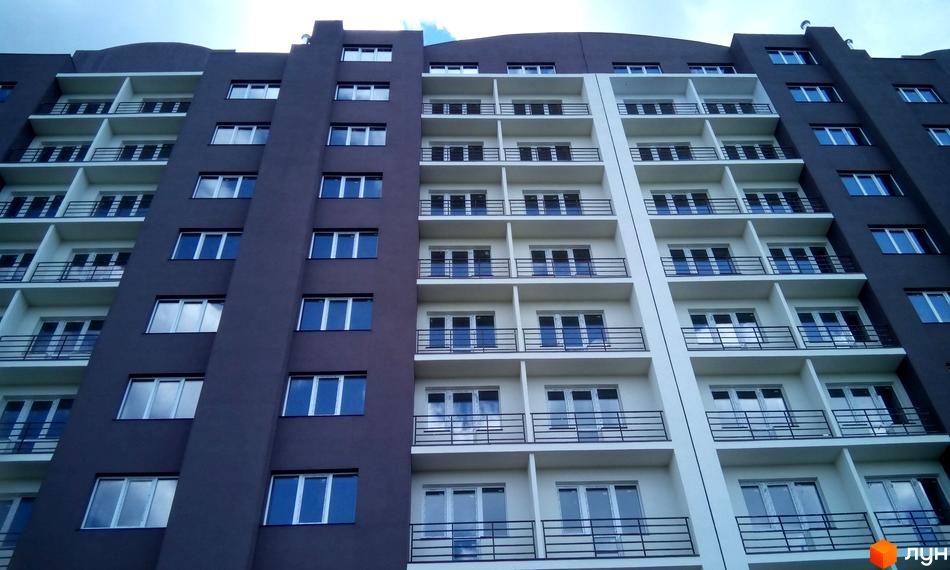 Фасад новобудови ЖК Вишнева оселя (вул. Дружби) з численними балконами та вікнами. Будинок має секції з темним та світлим оздобленням.