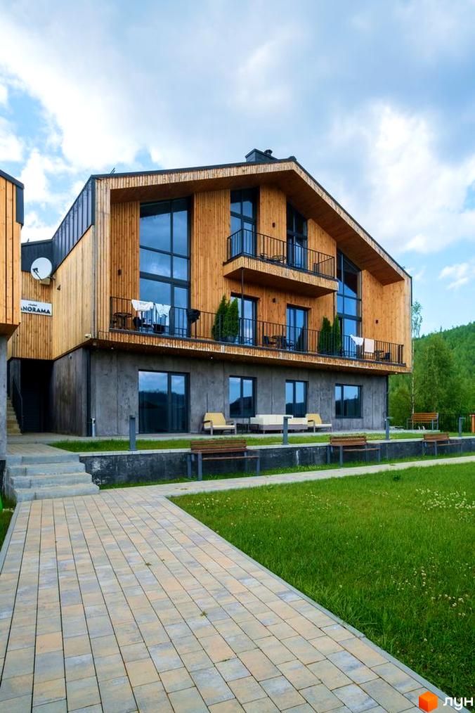 Апарт-готель Panorama Chalet – це чотириповерхова будівля з дерев'яним фасадом та великими вікнами, розташована на доглянутій території з газоном та доріжками.