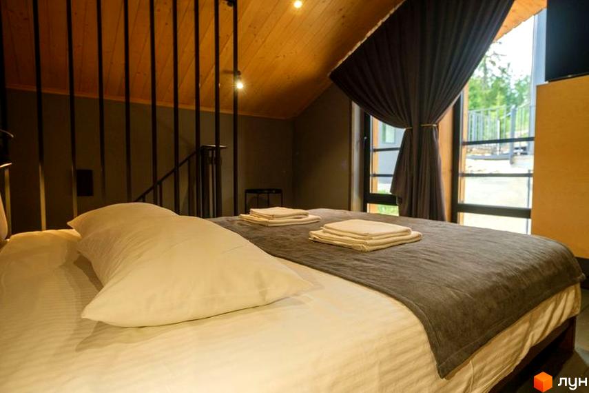 Апарт-готель Panorama Chalet: затишна спальня з великим вікном та видом на зелену територію. Сучасний дизайн інтер'єру для комфортного відпочинку.
