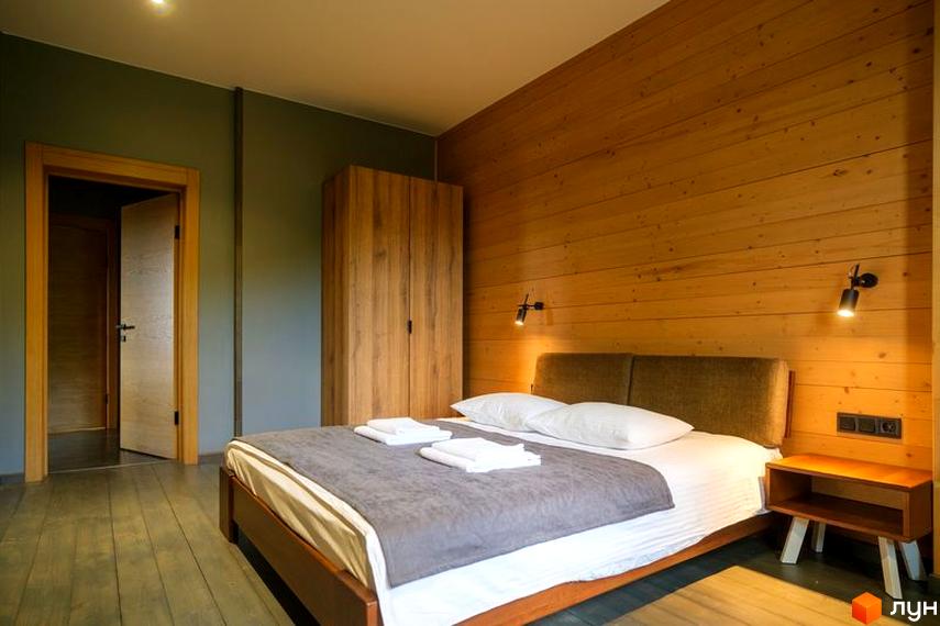 Апарт-готель Panorama Chalet: затишна спальня з дерев'яними акцентами та зручним ліжком. Сучасний дизайн інтер'єру для комфортного проживання.