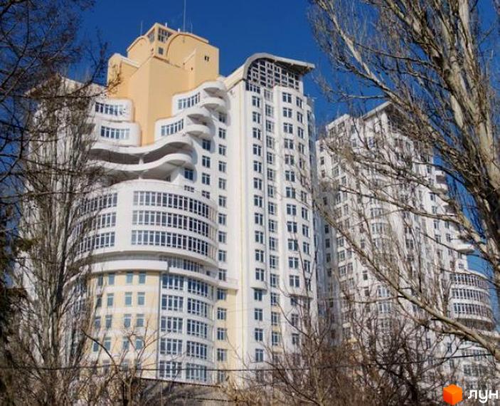 Житловий комплекс Французький бульвар, 22/30, з сучасним фасадом та великою кількістю вікон. Прибудинкова територія озеленена деревами.