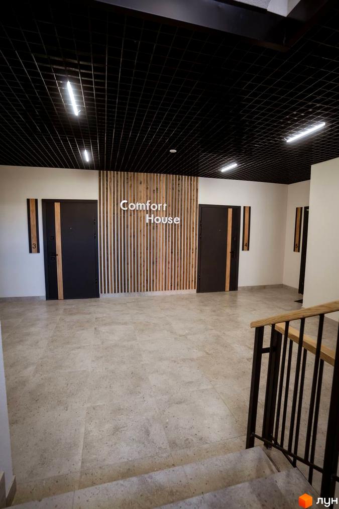 Новобудова Comfort House з сучасним дизайном фасаду та вхідною групою. Просторий хол з дверима та дерев'яними елементами.