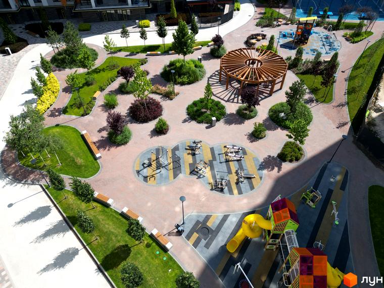 Житловий комплекс Атмосфера: вид зверху на зелену прибудинкову територію з дитячим майданчиком та зонами відпочинку.