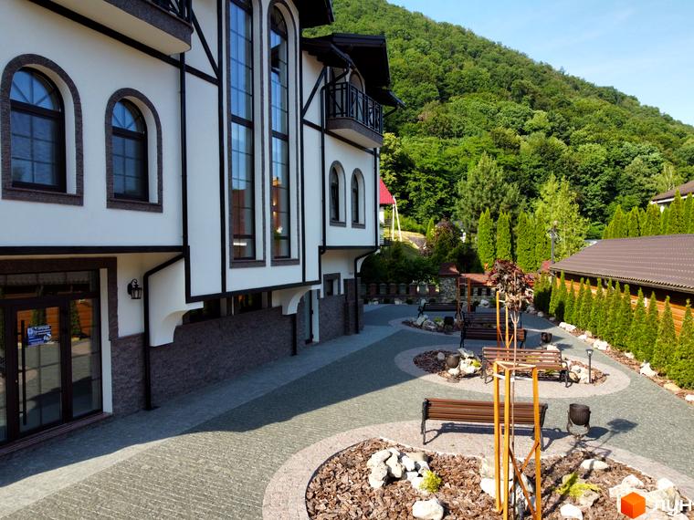 Житловий комплекс Shayan lux house з білою фасадною частиною та коричневими елементами, прибудинкова територія з ландшафтним дизайном та зонами відпочинку.