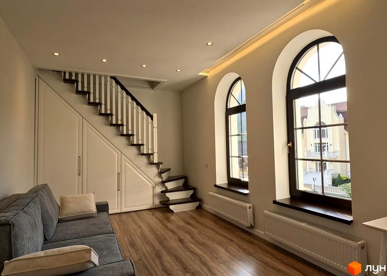 Житловий комплекс Shayan lux house з арковими вікнами та сходами, що ведуть до другого поверху. Навколо комплексу розташовані зелені насадження та паркувальні місця.