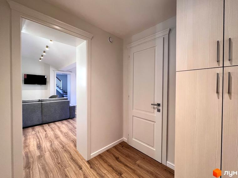 Житловий комплекс Shayan lux house: вид зсередини на двері та шафу, а також на вітальню з диваном та телевізором.