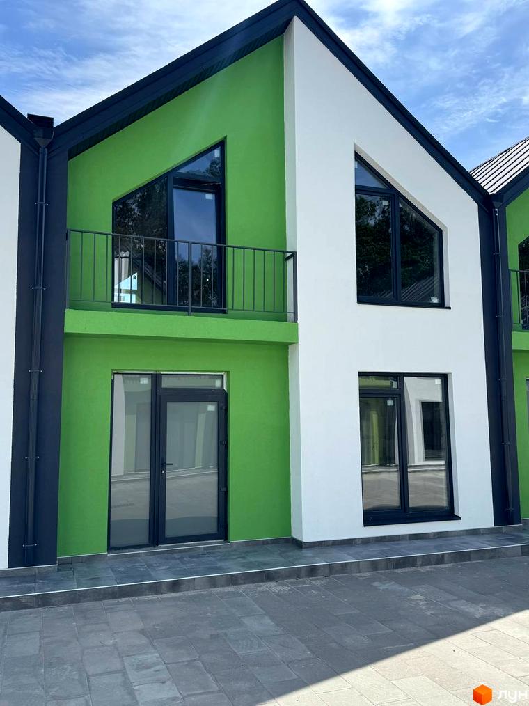 Таунхауси Freya: двоповерхові будинки з яскраво-зеленими та білими фасадами, великими вікнами та балконом. Прибудинкова територія вимощена плиткою.