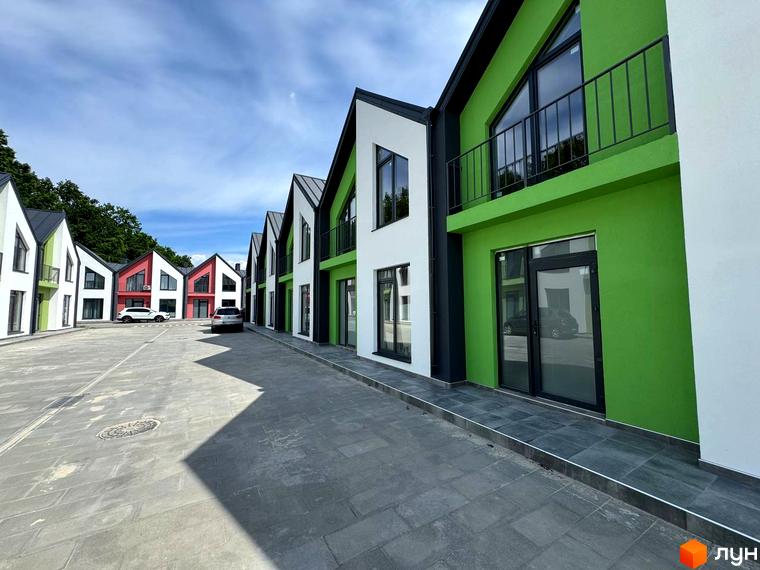 Таунхауси Freya - комплекс з яскравих будинків з панорамними вікнами та балконами, розташований на вимощеному подвір'ї з місцями для паркування.