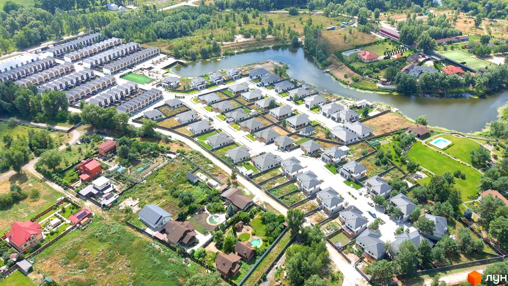 Котеджне містечко Prydesennya Eco Village з сучасними будинками та доглянутими прибудинковими територіями, що розташоване біля водойми.