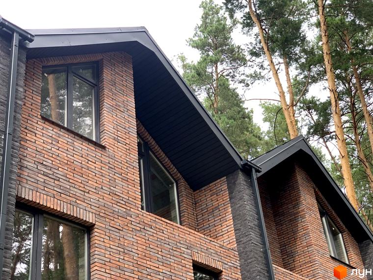 Таунхаус Forest Lane з цегляним фасадом та темним дахом на тлі соснового лісу. Зовнішній вигляд будинку, що ідеально вписується в природний ландшафт.