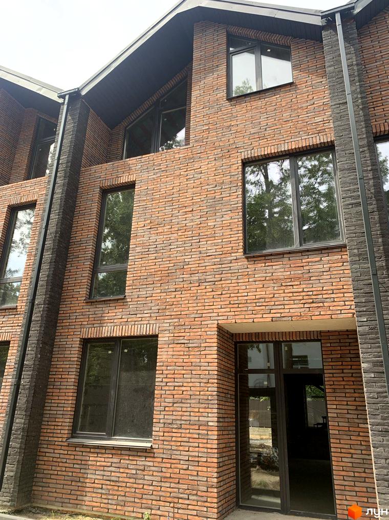 Фасад таунхаусу Forest Lane з цегляною кладкою та великими вікнами. Зовнішній вигляд будинку з елементами сучасної архітектури.