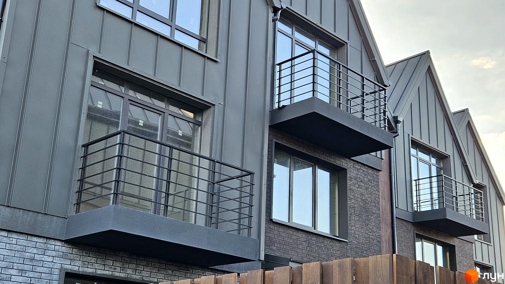 Таунхауси New Smart 17 з сірим фасадом та балконами. Зовнішній вигляд будівель з металевим дахом та цегляною кладкою.