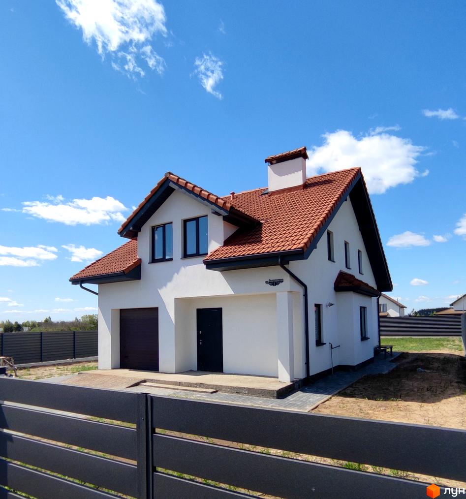 Зовнішній вигляд будинку КМ Ivankovo з червоною черепичною покрівлею та білими стінами. Навколо будинку розташована прибудинкова територія з парканом.