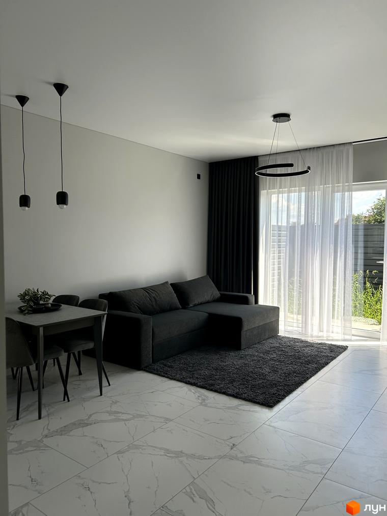 Інтер'єр вітальні в Peremohy Homes з диваном, столом та стільцями. Сучасний дизайн та функціональне планування.