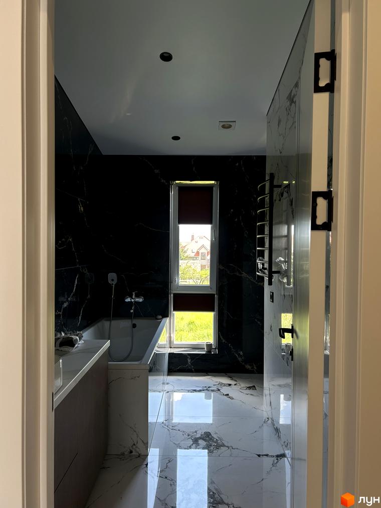 Ванна кімната в Peremohy Homes з мармуровою плиткою та великим вікном. Сучасна сантехніка та елегантний дизайн.