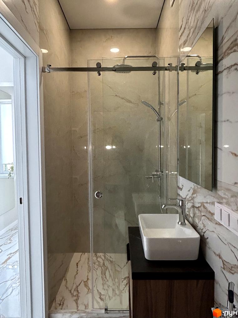 Сучасний дизайн ванної кімнати в Peremohy Homes з мармуровим оздобленням та скляною душовою кабіною. Огляд інтер'єру житлового комплексу.