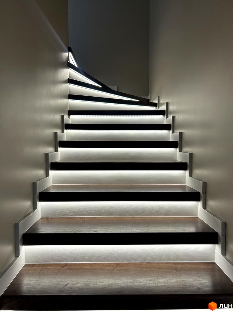 Сходи з підсвіткою в Peremohy Homes. Сучасний дизайн сходів з дерев'яними ступенями та білим оздобленням.