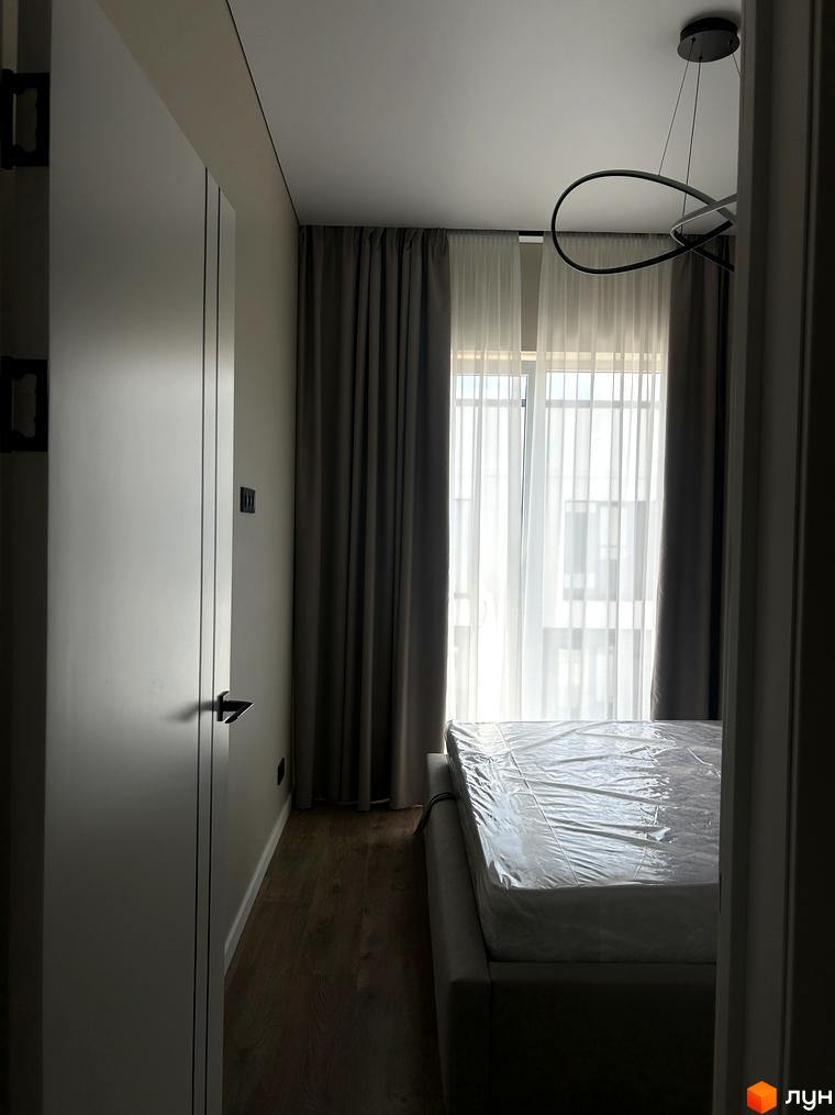 Peremohy Homes: спальня з великим вікном та шторами, ліжко під плівкою. Огляд інтер'єру новобудови.