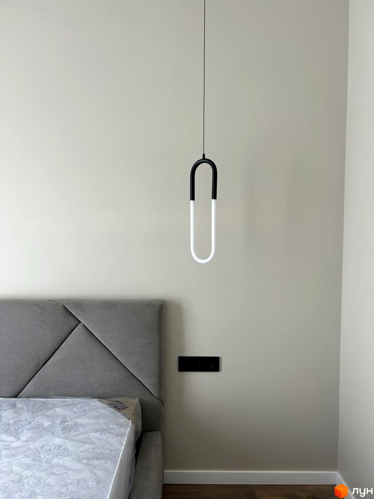 Дизайн спальні в Peremohy Homes з сірим узголів'ям та підвісним світильником. Сучасна новобудова для комфортного життя.