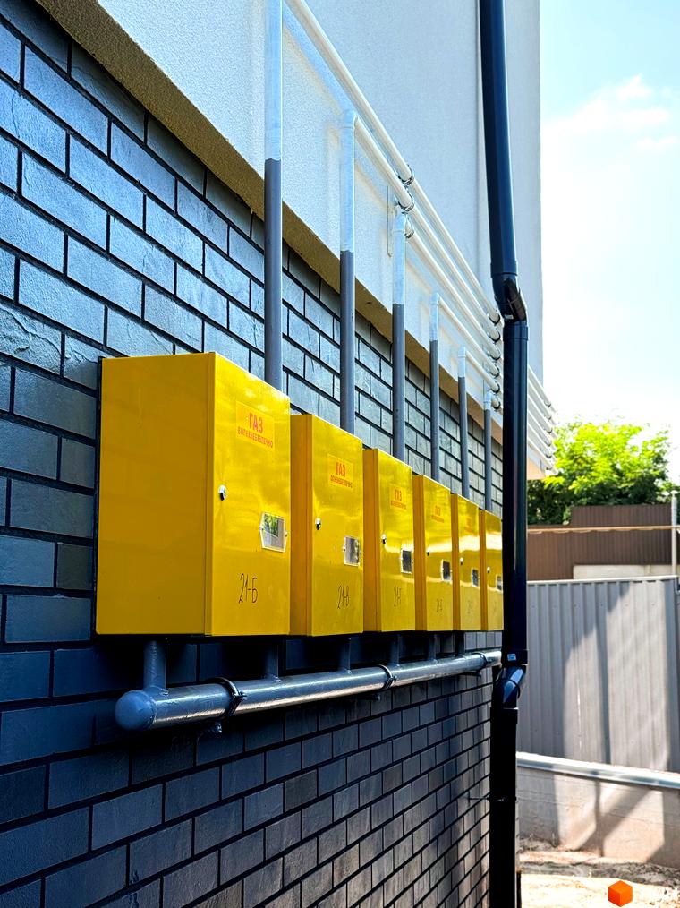 Зовнішній вигляд будинків житлового комплексу на вул. Троянівська, 21а. На фасаді встановлені жовті газові шафи.