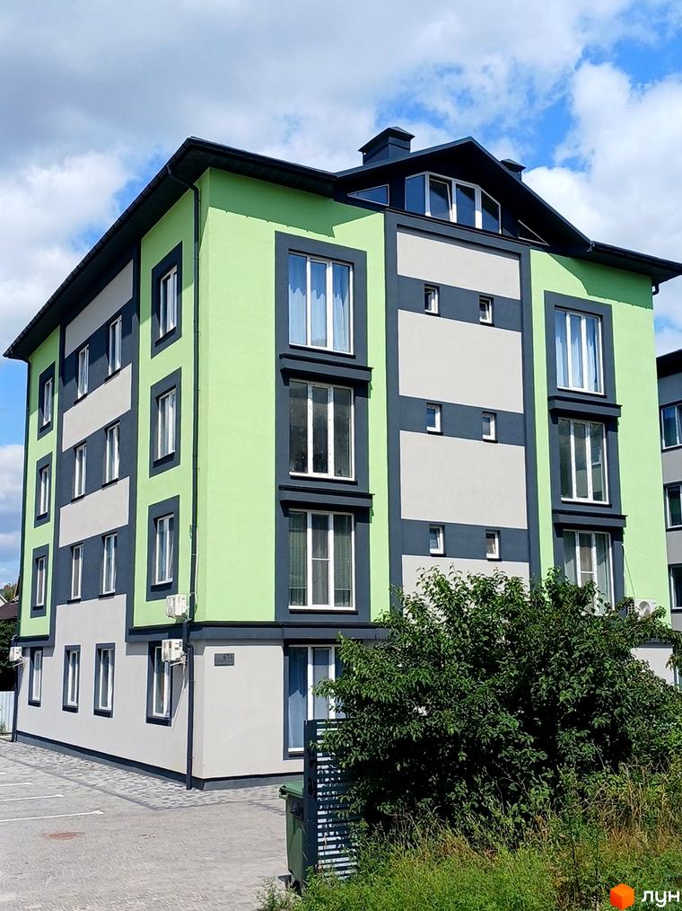 Зовнішній вигляд новобудови на вул. Інститутська, 67а, з яскраво-зеленими та сірими фасадами, вікнами та прибудинковою територією з парковкою та деревами.