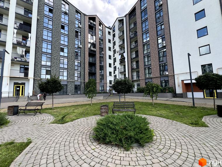 Житловий комплекс Scandia: фасади будинків з цегляним оздобленням та великими вікнами, внутрішній двір з зеленими насадженнями та зонами відпочинку.