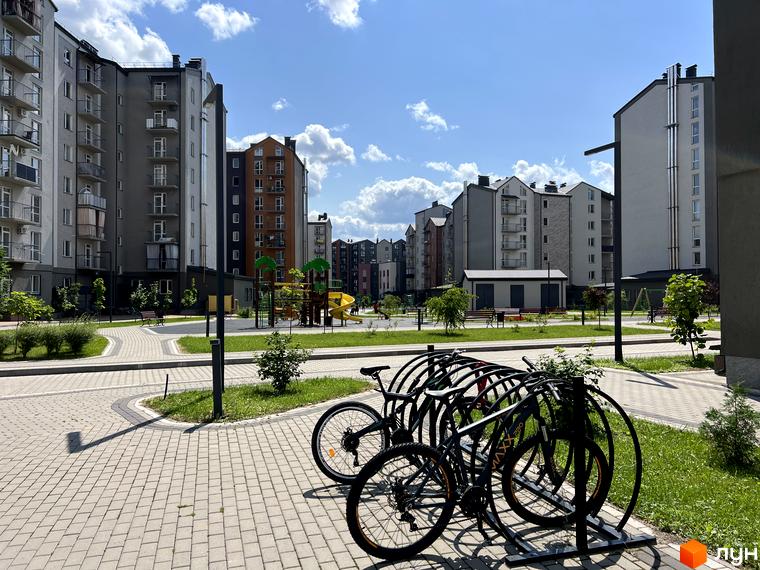 Житловий комплекс Scandia: сучасні багатоповерхові будинки з балконами та прибудинковою територією з дитячим майданчиком та велопарковкою.