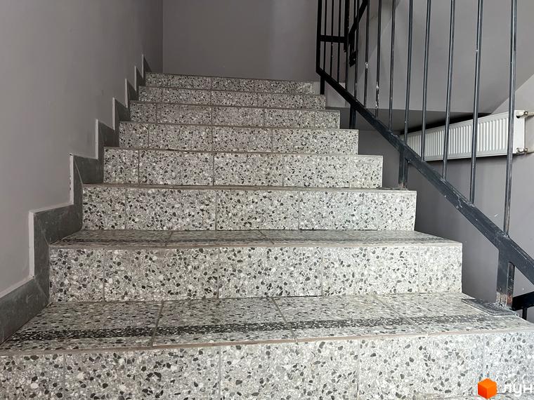 Сходи в ЖК Scandia з сірим оздобленням та чорними поручнями. Зовнішній вигляд сходів у житловому комплексі.