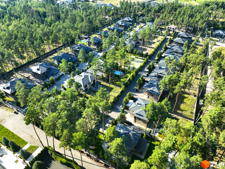 Котеджне містечко ZAHRAVA village 2: сучасні будинки з темними дахами та великими вікнами, оточені сосновим лісом та доглянутими ділянками.
