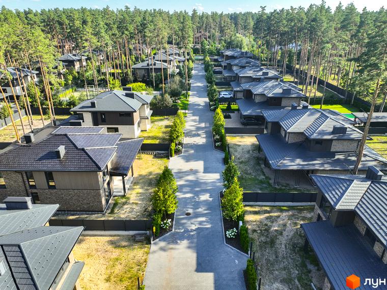 Котеджне містечко ZAHRAVA village 2: сучасні будинки з темними дахами та акуратними прибудинковими територіями, оточені соснами.