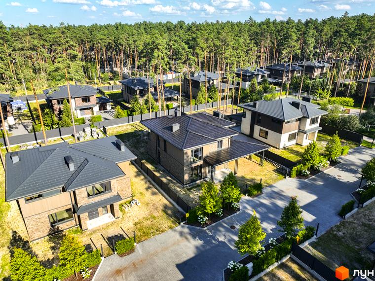 Котеджне містечко ZAHRAVA village 2. Сучасні двоповерхові будинки з темними дахами та цегляним фасадом, розташовані серед соснового лісу.