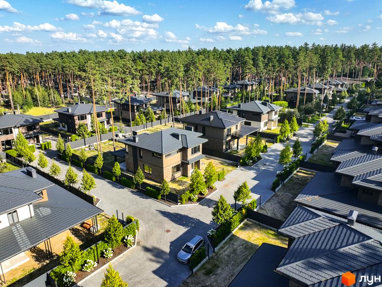 Котеджне містечко ZAHRAVA village 2: двоповерхові будинки з сірими дахами та цегляними фасадами, розташовані серед соснового лісу з доглянутими подвір'ями.