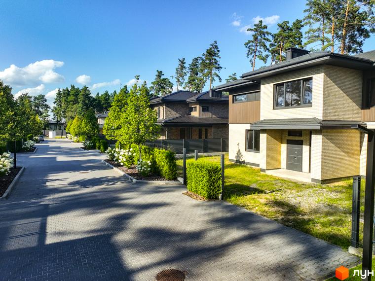 Котеджне містечко ZAHRAVA village 2. Сучасні будинки з цегляним фасадом та доглянутою прибудинковою територією з газоном та кущами.