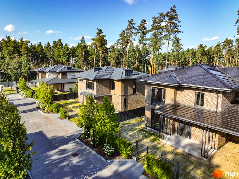 Котеджне містечко ZAHRAVA village 2. Зовнішній вигляд сучасних котеджів з цегляним фасадом та сірим дахом, розташованих серед соснового лісу.