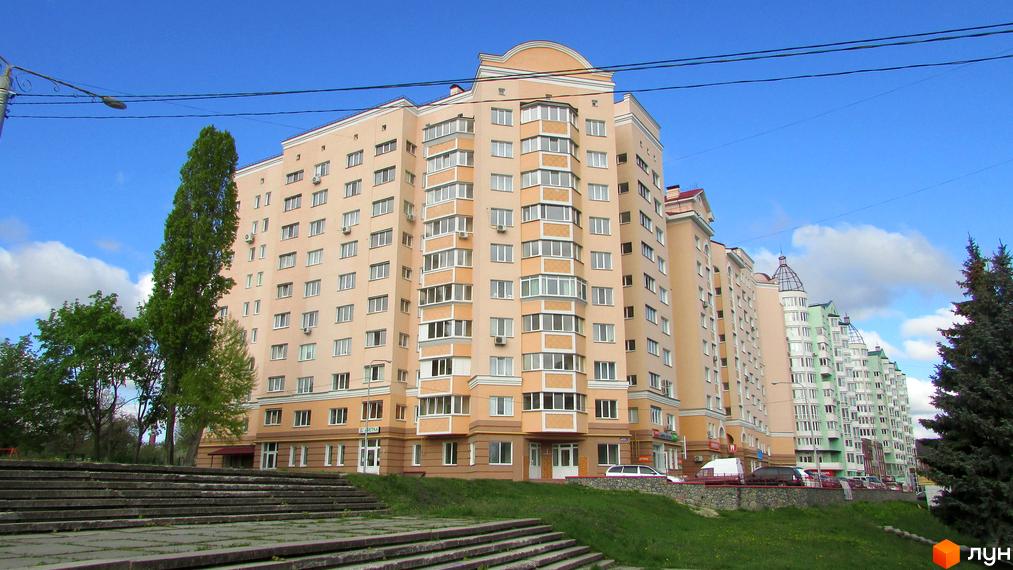 Багатоповерховий житловий комплекс на просп. Шевченка, 6а, з фасадами світло-бежевого кольору та балконами. Перед будинком розташовані сходи та зелена зона.