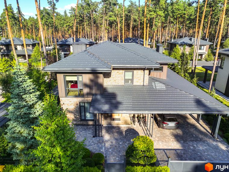 Котеджне містечко ZAHRAVA village 2. Будинок з сірим дахом, цегляними стінами та дерев'яними елементами, з навісом для авто та зеленою територією.