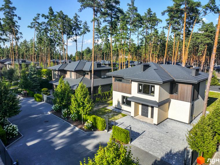 Котеджне містечко ZAHRAVA village 2. Сучасні будинки з сірими дахами та світлими фасадами, розташовані серед високих сосен.