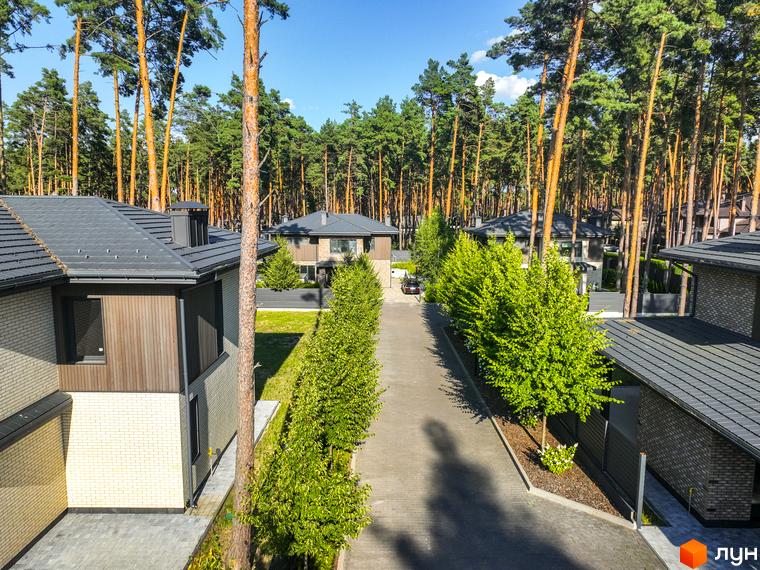 Котеджне містечко ZAHRAVA village 2. Сучасні будинки з темними дахами та фасадами, розташовані серед високих сосен.