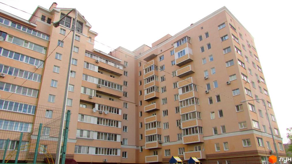 Зовнішній вигляд багатоповерхового житлового комплексу просп. Шевченка, 6а. На прибудинковій території видно дитячий майданчик та огорожу.