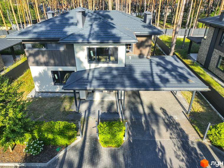 Котеджне містечко ZAHRAVA village 2: двоповерховий будинок з сірою черепицею та навісом для авто, оточений деревами та доглянутим ландшафтом.