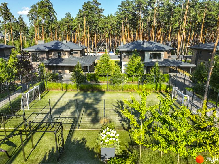 Котеджне містечко ZAHRAVA village 2 з футбольним полем та зоною для тренувань. Сучасні будинки оточені високими соснами.