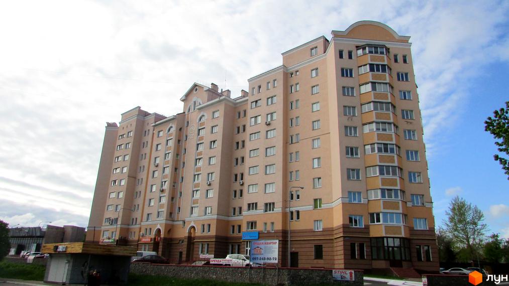 Фасад багатоповерхового будинку на просп. Шевченка, 6а, з численними вікнами та балконами. Навколо будинку облаштована прибудинкова територія з зеленими насадженнями.