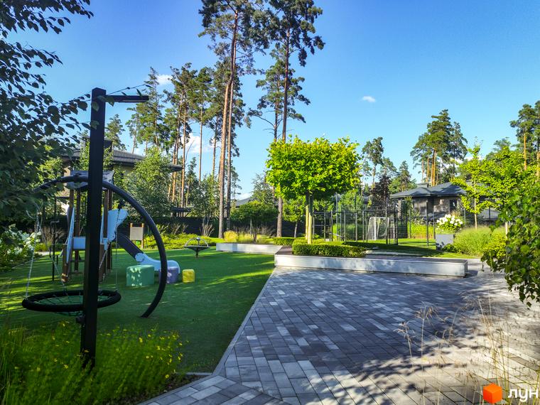 Котеджне містечко ZAHRAVA village 2. Дитячий майданчик та спортивна зона на фоні будинків та зелених насаджень.