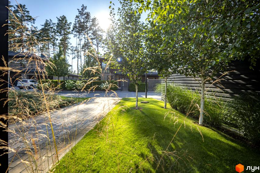 Котеджне містечко ZAHRAVA village 2. Зелений газон, вимощені доріжки та дерева на території котеджного містечка.