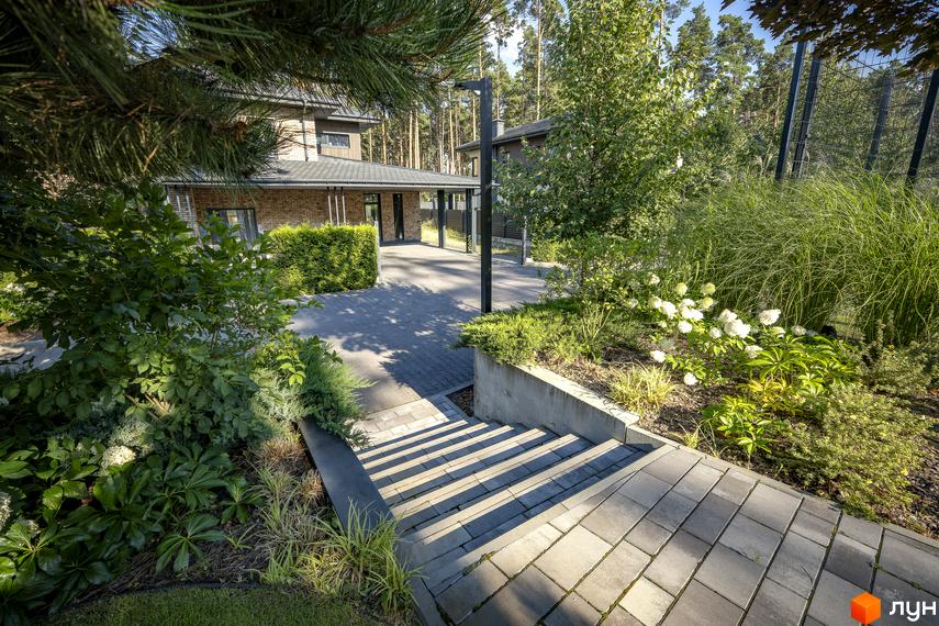 Котеджне містечко ZAHRAVA village 2: цегляний будинок з навісом та доглянутою прибудинковою територією зі сходами та зеленню.