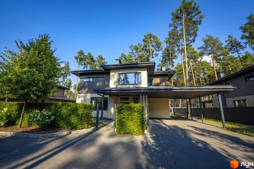 Котеджне містечко ZAHRAVA village 2. Зовнішній вигляд двоповерхового будинку з навісом для авто та доглянутою прибудинковою територією.