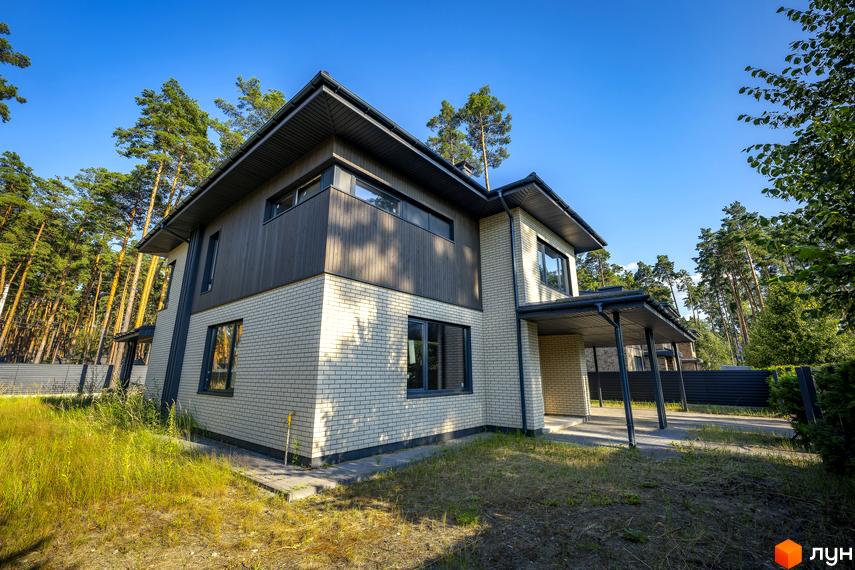 Котеджне містечко КМ ZAHRAVA village 2. Двоповерховий будинок з білої цегли та темних дерев'яних панелей, з навісом та доглянутою територією.