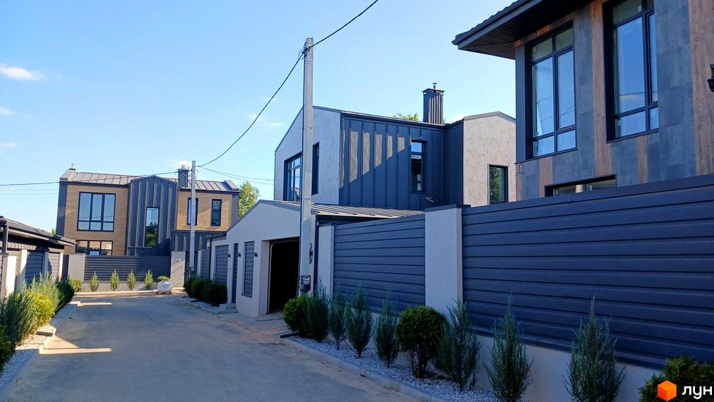 Сучасний житловий комплекс на вулиці Зелений Гай з фасадами з натуральних матеріалів та великими вікнами. Прибудинкова територія охайно впорядкована з доглянутими зеленими насадженнями.