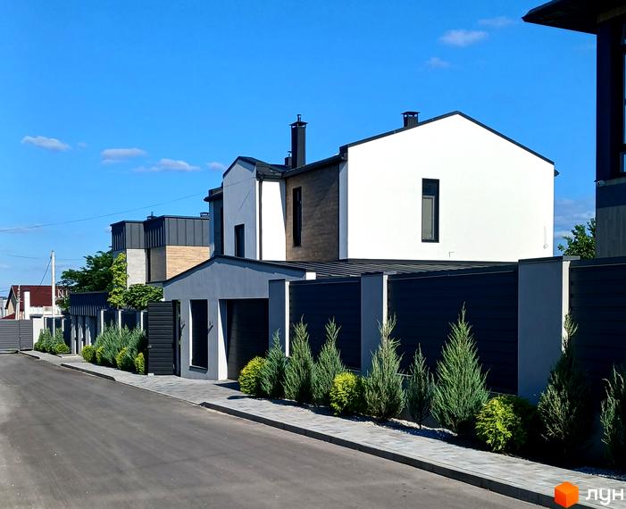 Сучасні будинки житлового комплексу на вул. Зелений Гай з доглянутою прибудинковою територією та акуратним парканом.